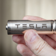 St. Petersburg, Russia - November 30, 2017: A close-up of the hand holds one lithium-ion cylindrical battery with a Tesla logo designed to power electric vehicles.